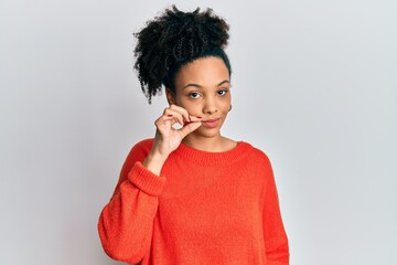 Young african american girl wearing casual clothes mouth and lips shut as zip with fingers. secret...