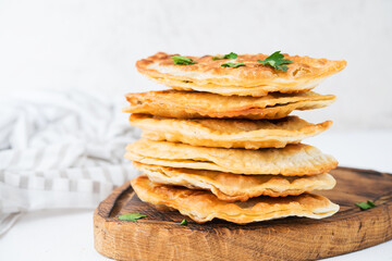 Homemade fried empanadas with pork, chebureks with mushrooms on a wooden board