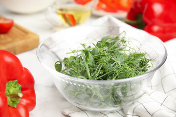 Fresh microgreen and other ingredients for tasty salad on white table, closeup