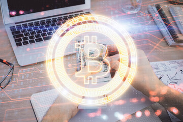 Multi exposure of blockchain theme drawing hologram and USA dollars bills and man hands. Business...