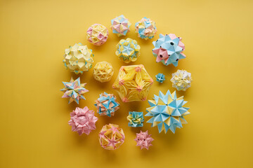 Set of multicolor handmade modular origami balls or Kusudama Isolated on yellow background. Visual...