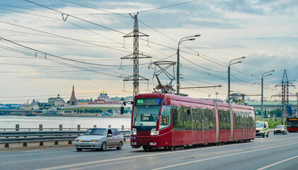 Fototapeta na wymiar Red modern tram on the street in Kazan, Russia. Tram in front of the Kazan Kremlin. 