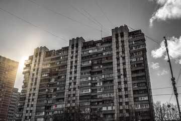 Fototapeta premium A gloomy Soviet high-rise building. Sunbeam. Old economy class building. 
