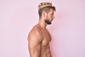 Young caucasian man shirtless wearing king crown looking to side, relax profile pose with natural...