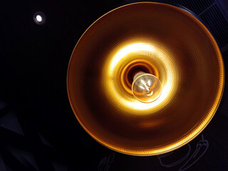 Close up of Illuminated light bulb on dark background. Lighting decor. Close-up of incandescent light bulbs hanging on the ceilings in a room.