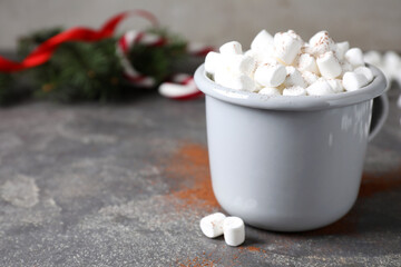 Fototapeta na wymiar Cup of tasty hot drink with marshmallows on grey table, closeup. Space for text