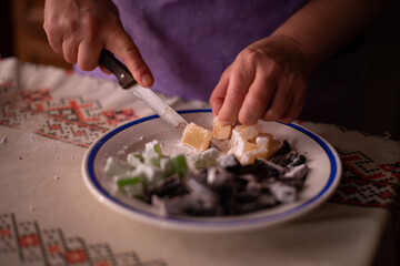 housewife slicing Turkish delicacies into small cubes on a plate