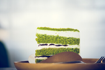 Piece triangle pandan layer cake filled with cream and red beans