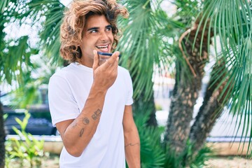 Young hispanic man having conversation talking on the smartphone at street of city