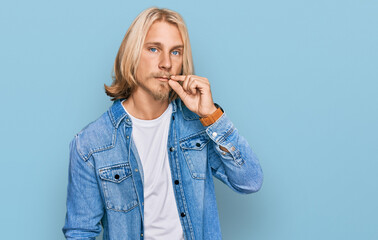 Caucasian man with blond long hair wearing casual denim jacket mouth and lips shut as zip with fingers. secret and silent, taboo talking © Krakenimages.com
