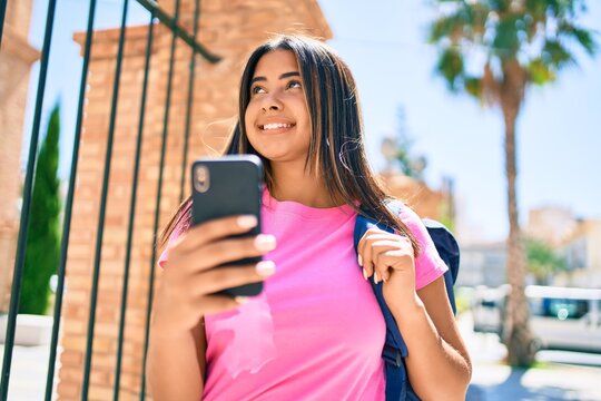 Young latin student girl smiling happy using smartphone at university campus.