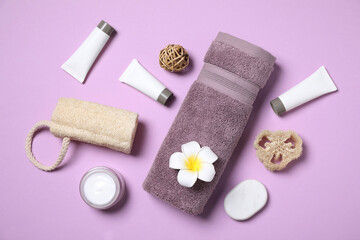 Obraz na płótnie Canvas Flat lay composition with different cosmetic products and flower on lilac background
