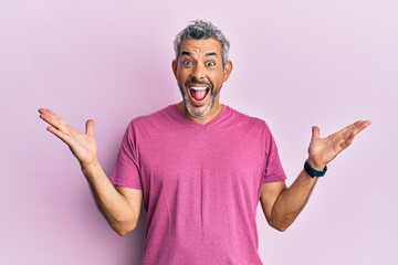 Fototapeta premium Middle age grey-haired man wearing casual clothes celebrating victory with happy smile and winner expression with raised hands