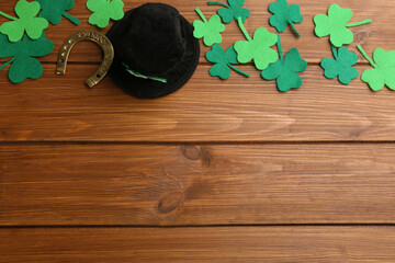 Flat lay composition with leprechaun hat on wooden table, space for text. St Patrick's Day...
