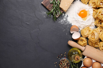 Flat lay composition with homemade pasta on black table. Space for text