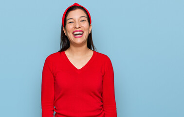 Young hispanic woman wearing casual clothes winking looking at the camera with sexy expression,...
