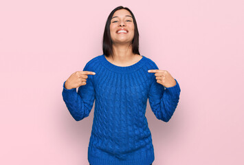 Young hispanic woman wearing casual clothes looking confident with smile on face, pointing oneself...
