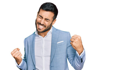 Young hispanic man wearing business jacket very happy and excited doing winner gesture with arms...