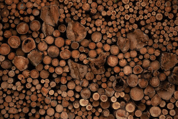 Background of cut wood logs stacked in a pile. wood for the production of chipboard