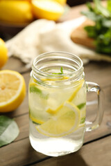 Mason jar of cold lemonade on wooden table