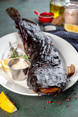 Cooked catfish on fire in a white plate
