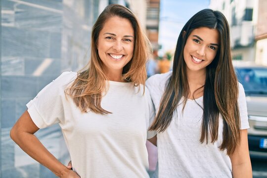 Beautiful hispanic mother and daughter smiling happy standing at the city.