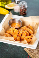 Fried shrimps in a white plate on a blue background