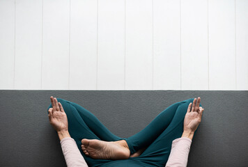 Closeup of young woman meditating and practicing yoga at home, panoramic banner with copy space....