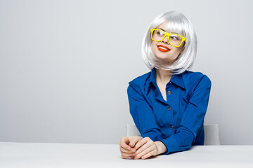 attractive woman in white wig yellow glasses red lips blue shirt