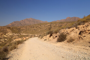 Camino de montaña por paisaje árido del sureste español. Paisaje Protegido de la Sierra de las Moreras, Mazarrón (Murcia-España).