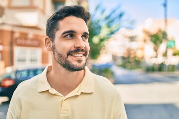 Obraz premium Young hispanic man smiling happy walking at the city.