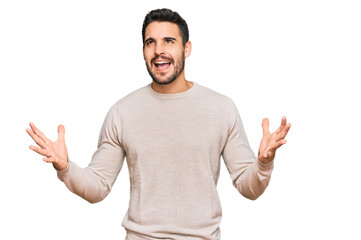 Fototapeta premium Young hispanic man wearing casual clothes crazy and mad shouting and yelling with aggressive expression and arms raised. frustration concept.