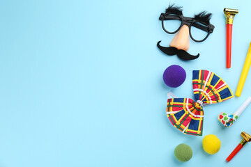 Flat lay composition with clown accessories on light blue background. Space for text