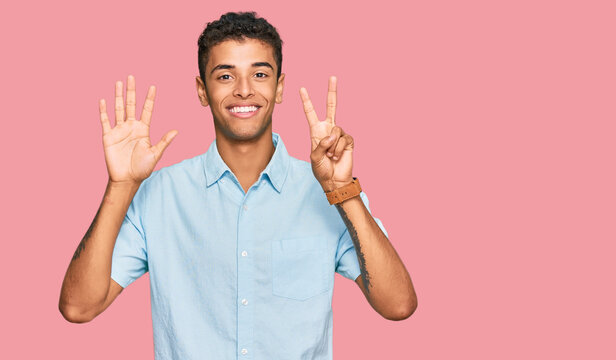 Young handsome african american man wearing casual clothes showing and pointing up with fingers number seven while smiling confident and happy.