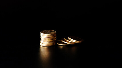 stacks of gold coin on black background concept saving money