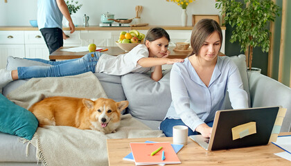 Social Distancing. A Busy Mother Tries to Work Remotely with Her Child and Husband at Home. The...