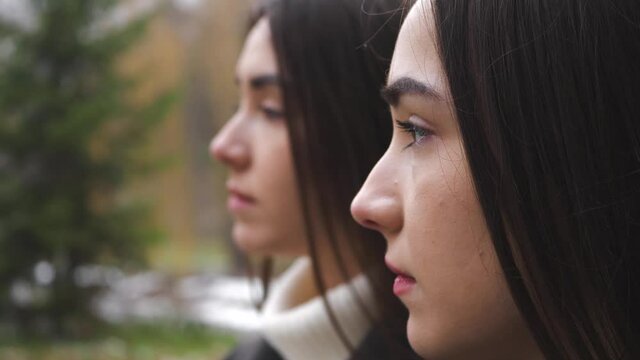 Outdoor portrait of Two Serious Twin Sisters' Profile