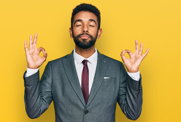 Young african american man wearing business clothes relax and smiling with eyes closed doing meditation gesture with fingers. yoga concept.