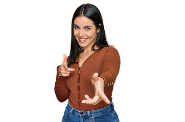 Young hispanic woman wearing casual clothes pointing fingers to camera with happy and funny face. good energy and vibes.