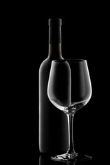 red wine bottle and wine glass isolated on black background