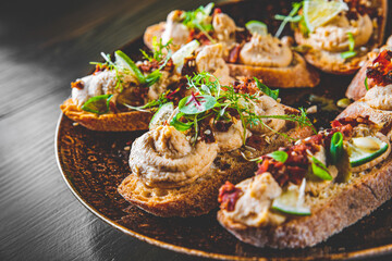 Fresh bruschettas pate in plate on wooden table background