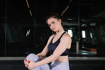 Woman poses in the gym. Close up attractive woman looks sexy.