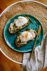 macro photo of a sandwich with a boiled poached egg on a plate with a golden fork
