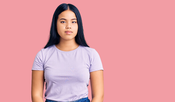Young beautiful asian girl wearing casual clothes with serious expression on face. simple and natural looking at the camera.