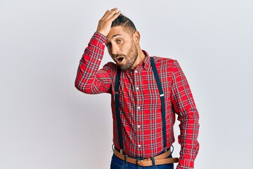 Handsome man with beard wearing hipster elegant look surprised with hand on head for mistake,...