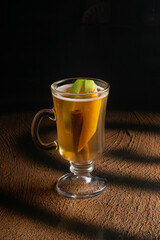 Hot fruit tea with apple, orange and cinnamon in a clear glass