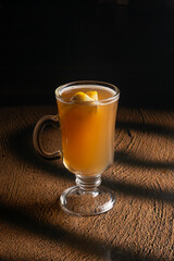 Hot fruit tea with orange and honey in a clear glass