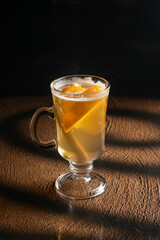 Hot ginger tea with orange and cinnamon in a clear glass