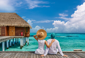 Couple in white on a tropical beach jetty - 415376468
