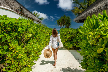 Woman with bag and sun hat going to beach